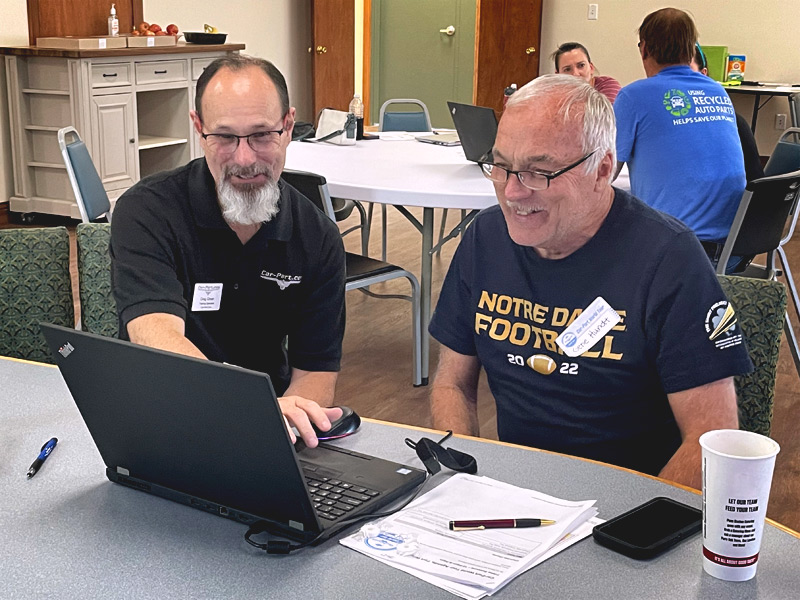 Photo of two people looking at a laptop